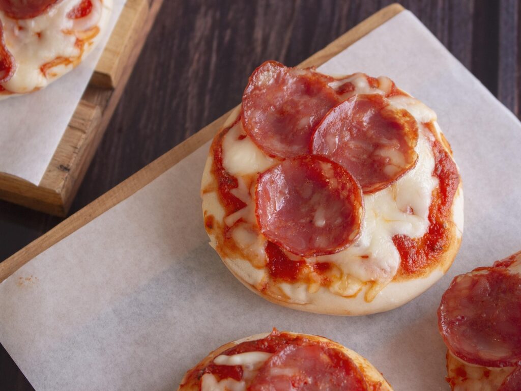 foto van een paar mini pizza's met salami erop