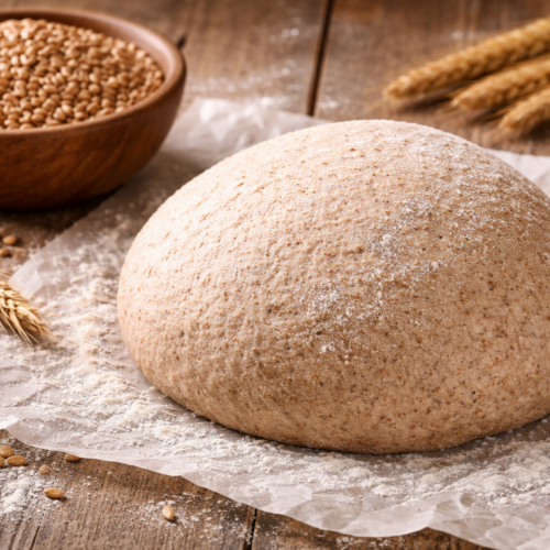 foto van een bol gerezen volkoren pizzadeeg