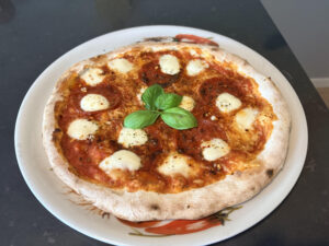 foto van een pizza diavola die net uit de oven komt