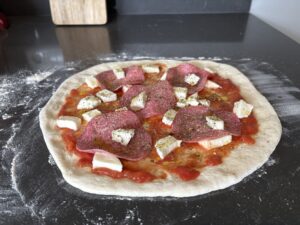 foto van een pizza salami voordat deze de oven in gaat