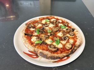 Afbeelding van een vers gebakken pizza ai Funghi