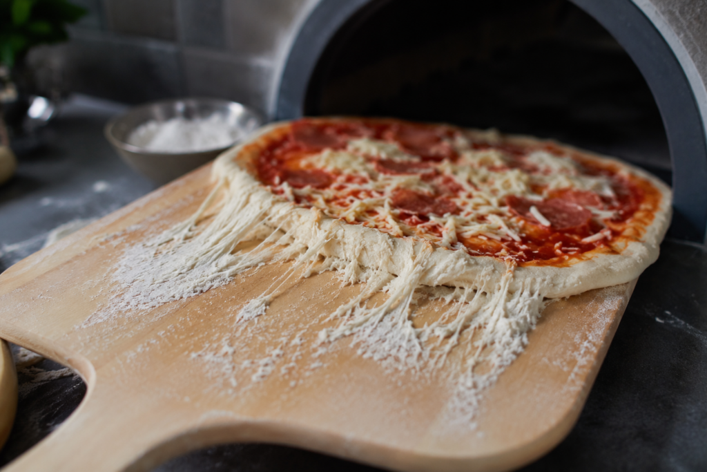 afbeelding van een pizza die aan de schep blijft plakken