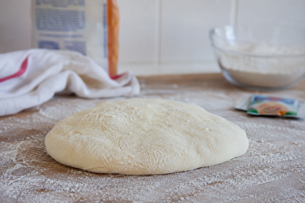 Pizzadeeg rijst niet. Afbeelding van een platte klont pizzadeeg