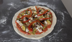foto van een pizza Ortolana voordat deze de oven in gaat