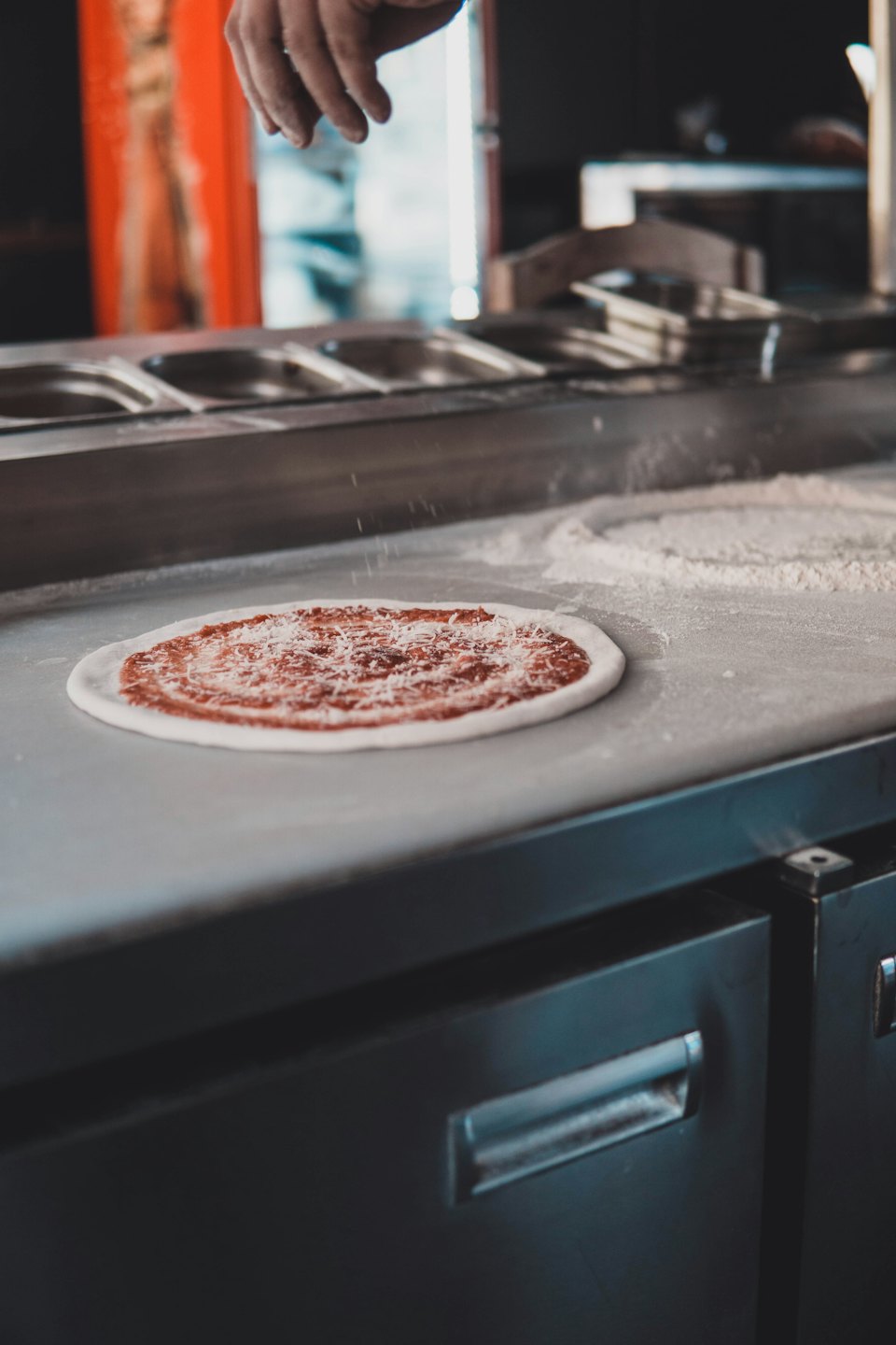 foto van een pizza margherita voordat deze de oven in gaat